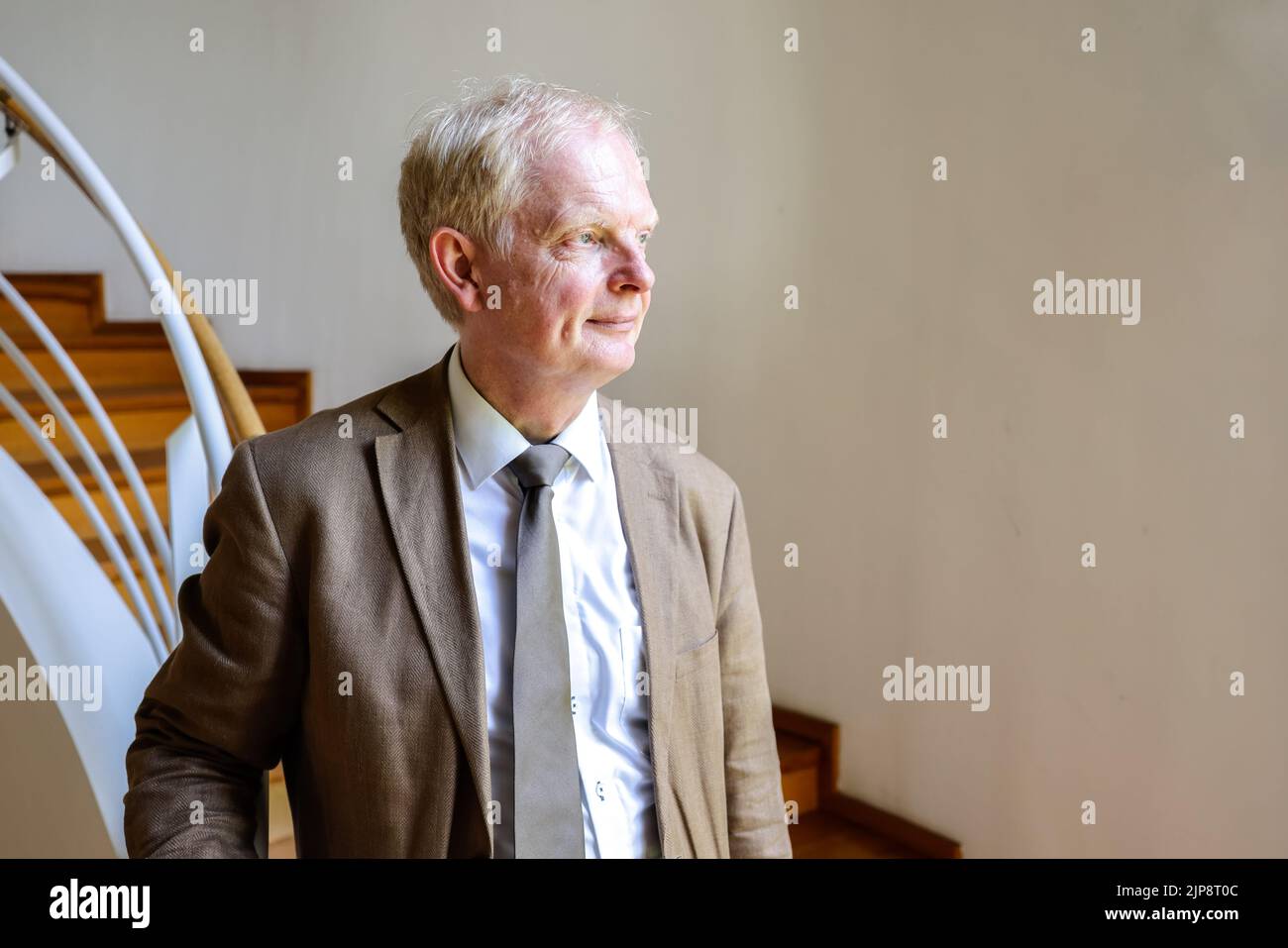 16 de agosto de 2022, Schleswig-Holstein, Schleswig: Rainer Hering, director principal de archivos de los archivos estatales de Schleswig-Holstein, mira por la ventana una foto de retrato. El 17 de agosto de 2022, la exposición 'Heinz Reinefarth. Del criminal de guerra nazi al miembro del parlamento del Estado' se abrirá. Reinefarth era un teniente general alemán de las Waffen SS y fue responsable, entre otras cosas, de la represión del Levantamiento de Varsovia, en el que decenas de miles de civiles fueron fusilados bajo su mando. Reinefarth nunca fue procesado por sus acciones. Logró embarcarse en una carrera política Foto de stock