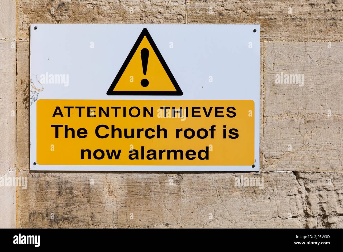 Advertencia para ladrones de techo de plomo en la pared de la Iglesia Parroquial de St Andrew, Aldborough, Yorkshire, Inglaterra. 'ladrones de atención. El techo de la Iglesia es ahora alar Foto de stock