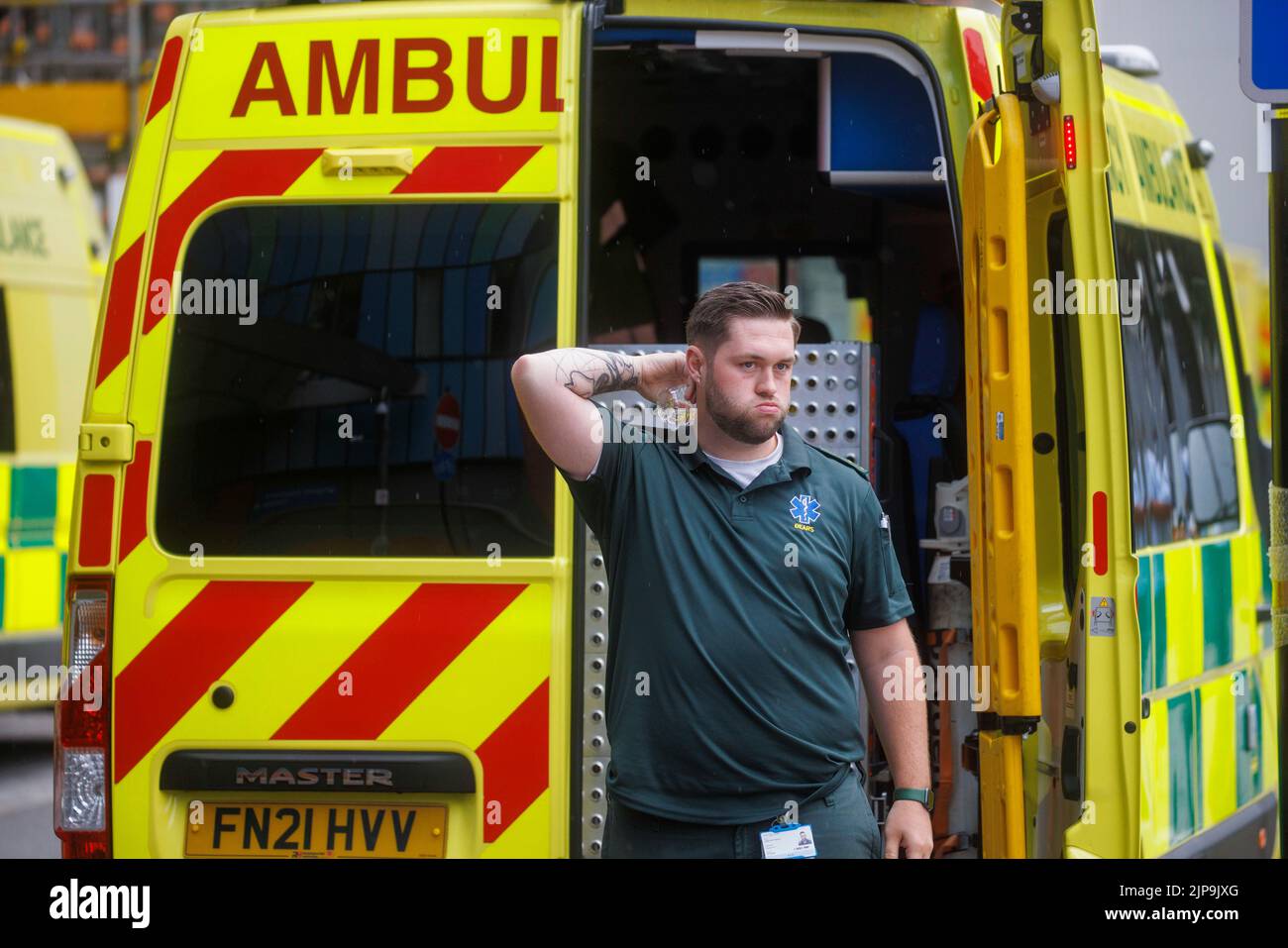 Un trabajador de ambulancia toma un descanso durante un turno durante el calor del verano. El servicio de ambulancia está bajo presión con mayor carga de trabajo. Foto de stock