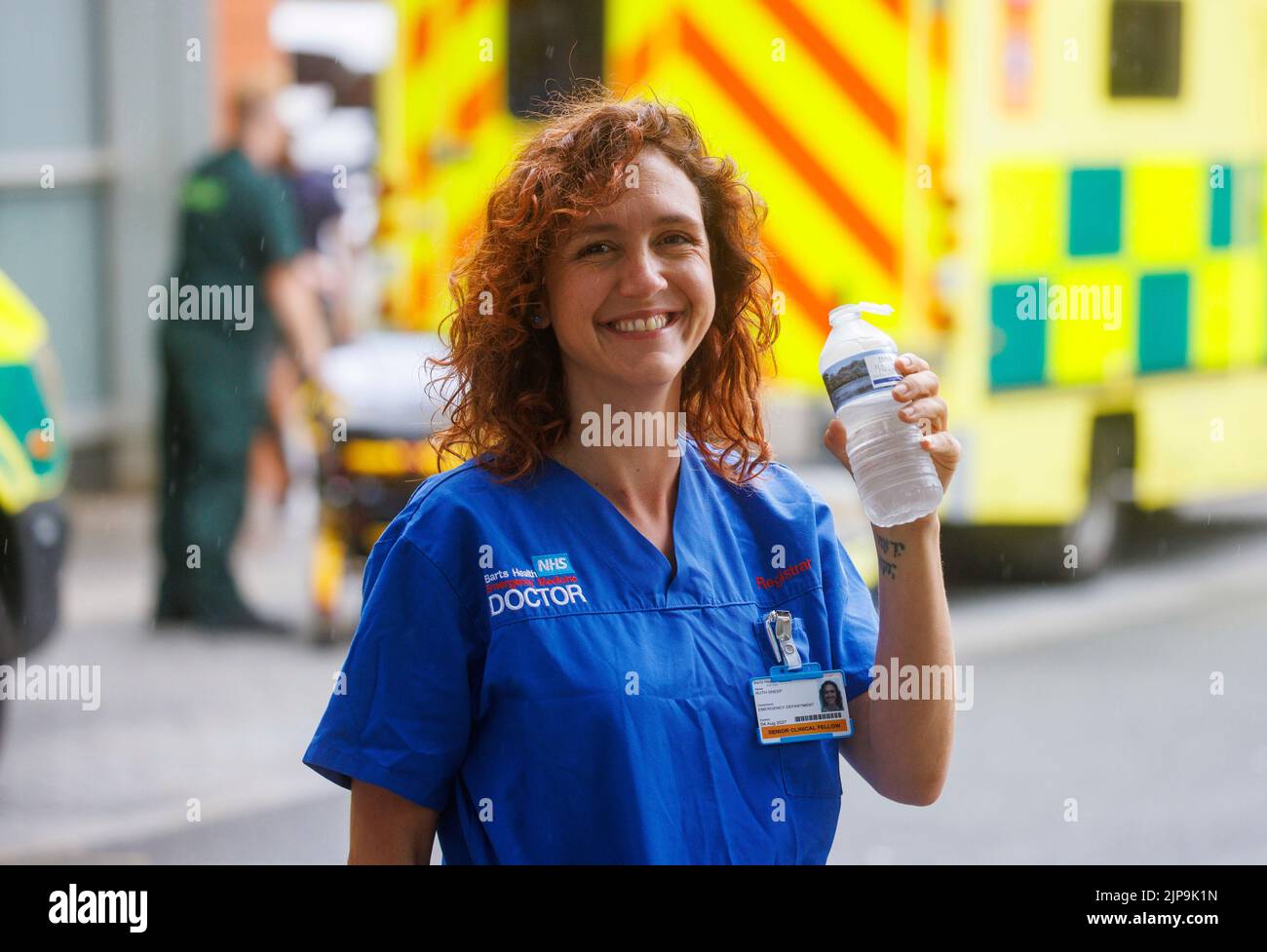 Un médico del NHS se refresca con una bebida de agua durante un descanso en un hospital de Londres. El NHS está bajo presión con la falta de fondos y la presión laboral. Foto de stock
