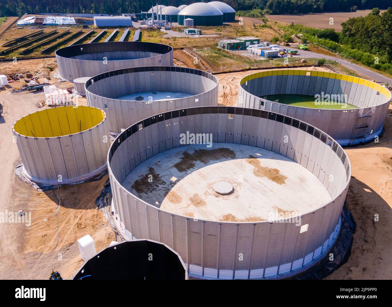 Torgelow, Alemania. 16th de Ago de 2022. Los primeros tanques de gas todavía en construcción para la futura planta de biogás. (Fotografía aérea tomada con un zumbido). La planta abastecerá a 15.000 habitantes de la ciudad de Torgelow. La planta de la empresa Mele Biogas, que hasta ahora consta de seis tanques de almacenamiento, se ampliará para duplicar su capacidad en otoño de 2023. Según la Asociación Estatal de Mecklemburgo-Pomerania Occidental para la Energía Renovable, aquí se producirá un volumen de energía de más de 100 millones de kilovatios hora al año, que también se introducirá en la red de gas natural. Crédito: Jens/dpa/Alamy Live News Foto de stock