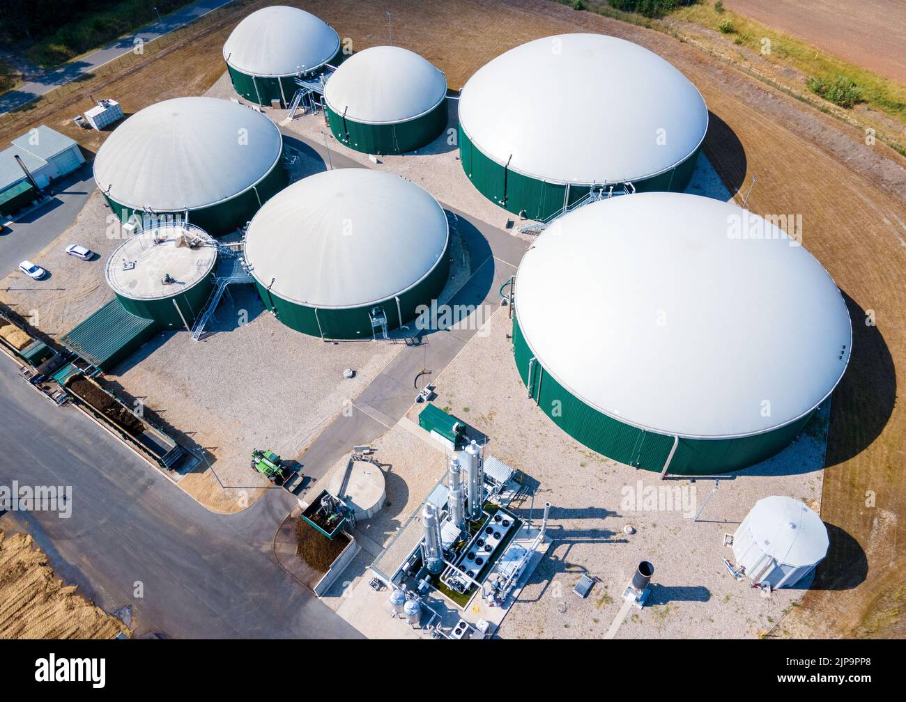 Torgelow, Alemania. 16th de Ago de 2022. La planta de biogás en Torgelow con un total de seis grandes tanques. (Fotografía aérea tomada con un zumbido). La planta abastecerá a 15.000 habitantes de la ciudad de Torgelow. La planta de la empresa Mele Biogas, que anteriormente constaba de seis tanques de almacenamiento, se ampliará para duplicar su capacidad hacia el otoño de 2023. Según la Asociación Estatal de Mecklemburgo-Pomerania Occidental para la Energía Renovable, aquí se producirá un volumen de energía de más de 100 millones de kilovatios hora al año, que también se introducirá en la red de gas natural. Crédito: Jens Büttner/dpa/Alamy Live News Foto de stock