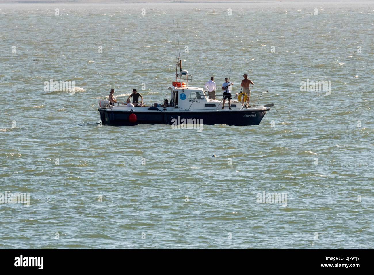 Pescadores de caña en un pequeño barco en el estuario del Támesis, frente a Southend on Sea, Essex, Reino Unido. Pesca de agua salada en el río Támesis Foto de stock