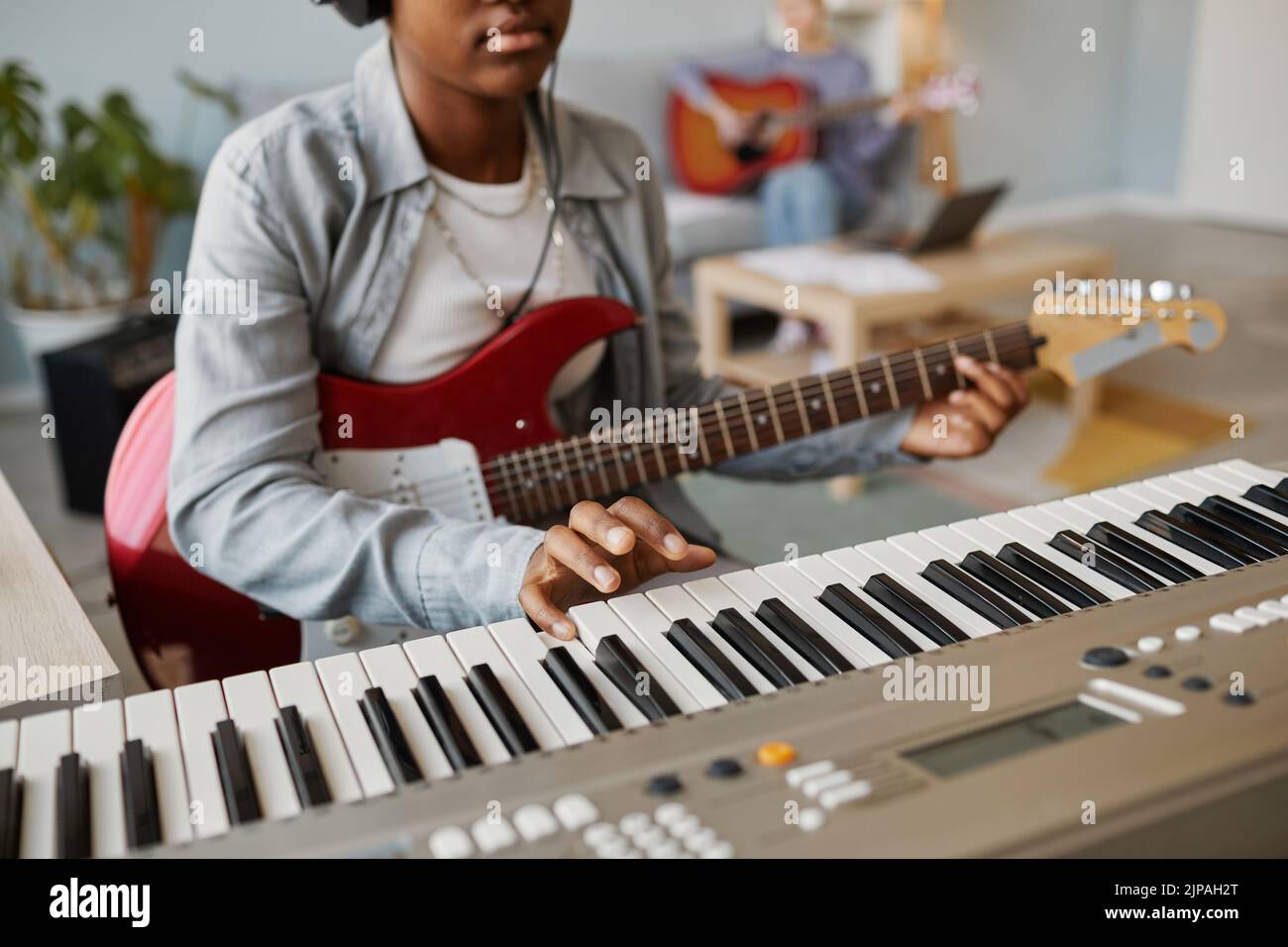 Primer plano de una joven negra pulsando la tecla del piano mientras compone música en casa, espacio de copia Foto de stock