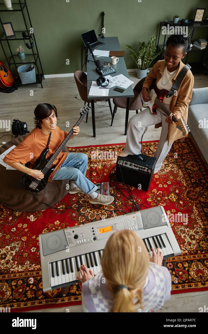 Imagen superior de una diversa banda musical tocando instrumentos mientras practicaba en el estudio sobre una alfombra ornamental pesada Foto de stock