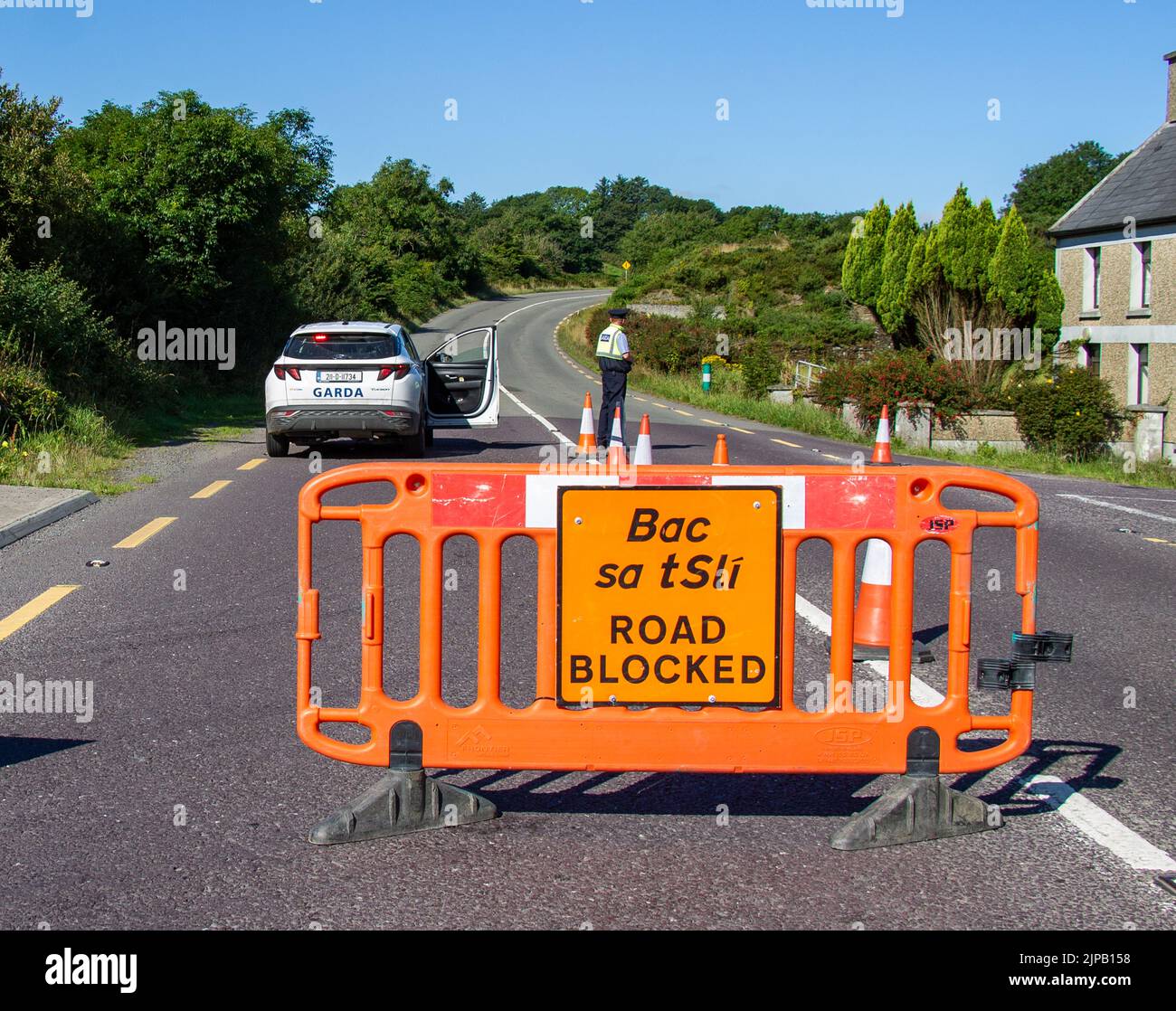 Policía Irlandesa Un bloque de carretera de Garda Siochana con señales y barreras Foto de stock