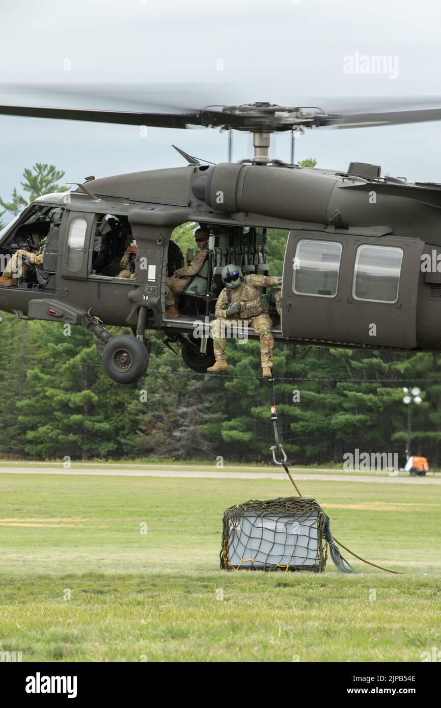 Soldados del Ejército de los EE.UU., Batallón de Apoyo de Brigada 237th, Cleveland, Ohio, se preparan para levantar una carga que contiene fluidos IV mientras que conduce una misión de carga de cabestrillo en el Campo de Desfile de Camp Grayling, Grayling, Mich., el 14 de agosto de 2022 durante el Ejercicio de Huelga Norte 22-2. Northern Strike está diseñado para desafiar a aproximadamente 7.400 miembros del servicio con múltiples formas de capacitación que promueven la interoperabilidad entre socios multicomponentes, multinacionales e interinstitucionales. (EE. UU Foto del Ejército por Sgt. Dustin Stewart). Foto de stock