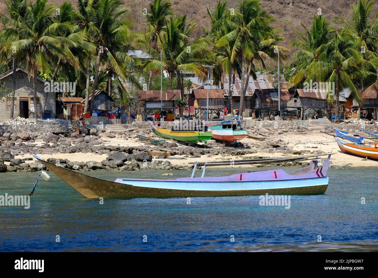 Indonesia Alor Island - maravillosa costa con barco de pesca y pueblo Foto de stock