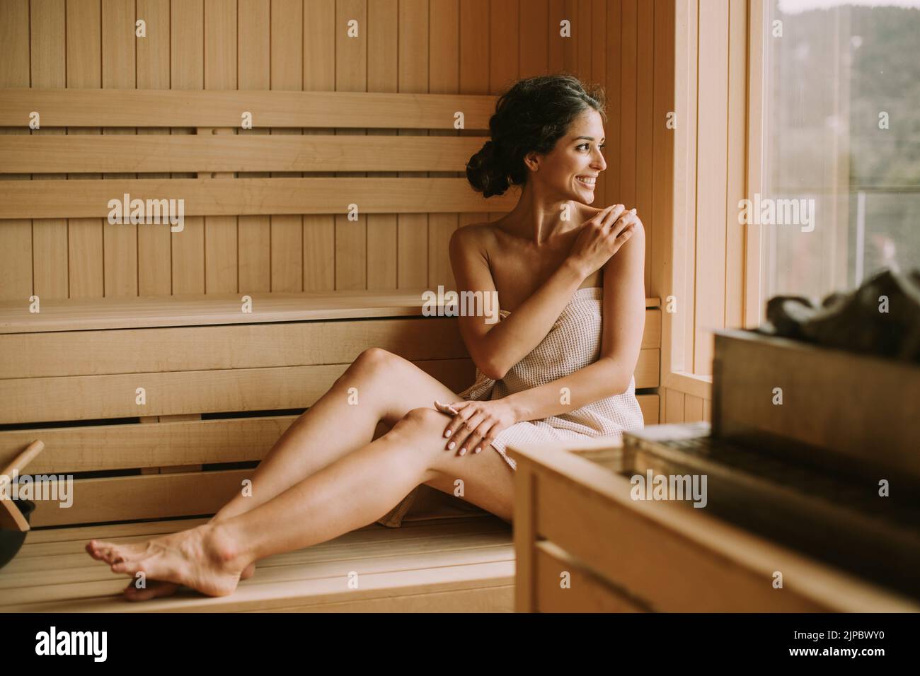 Atractiva mujer joven que se relaja en la sauna Foto de stock