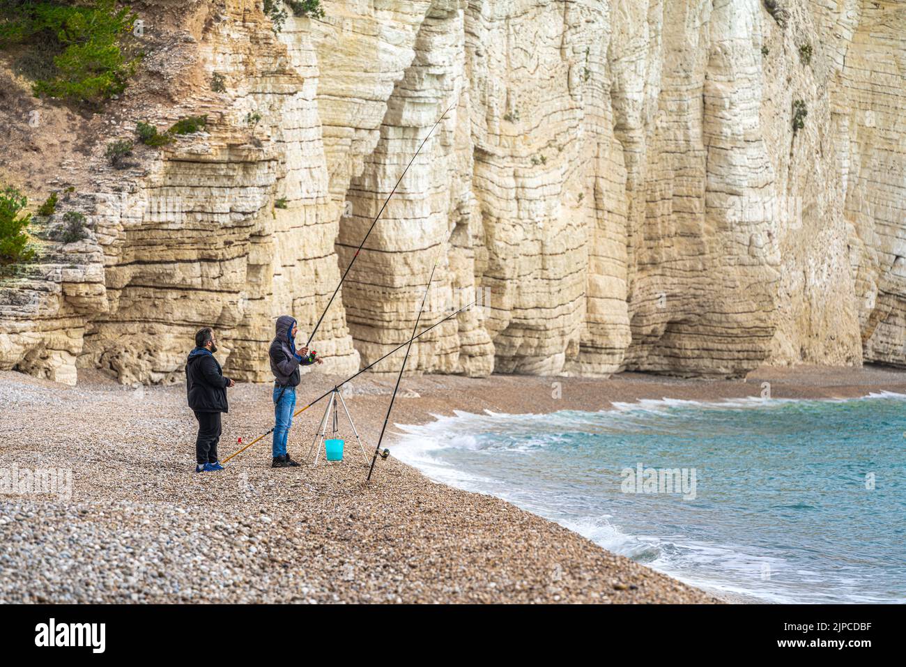 Pescadores en la playa de Vignanotica bajo los acantilados blancos. Mattinata, Provincia de Foggia, Gargano, Puglia, Italia, Europa Foto de stock