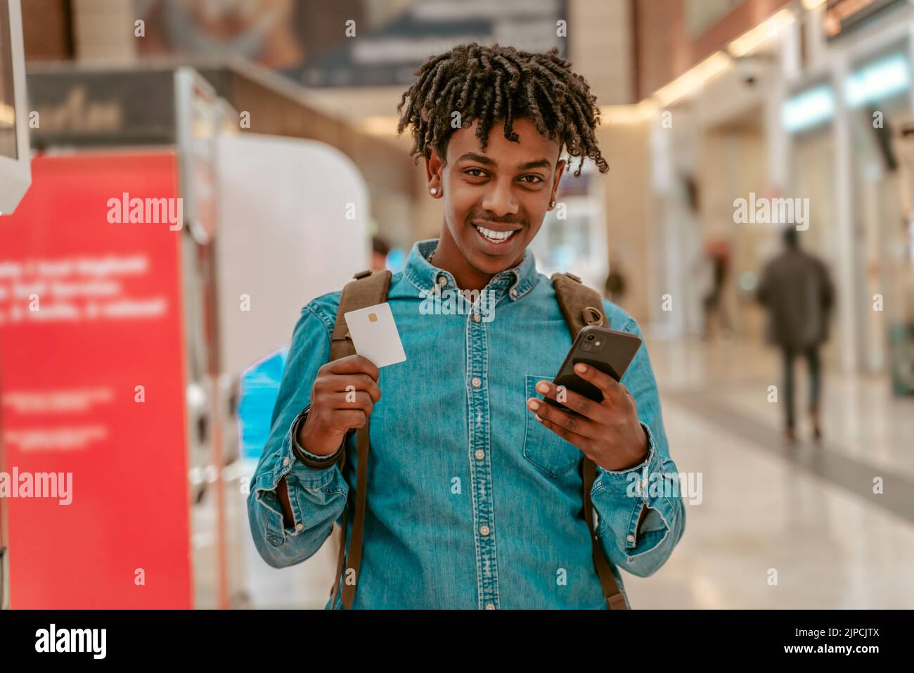 Un hombre feliz mostrando la entrada a la cámara de pie en la estación Foto de stock