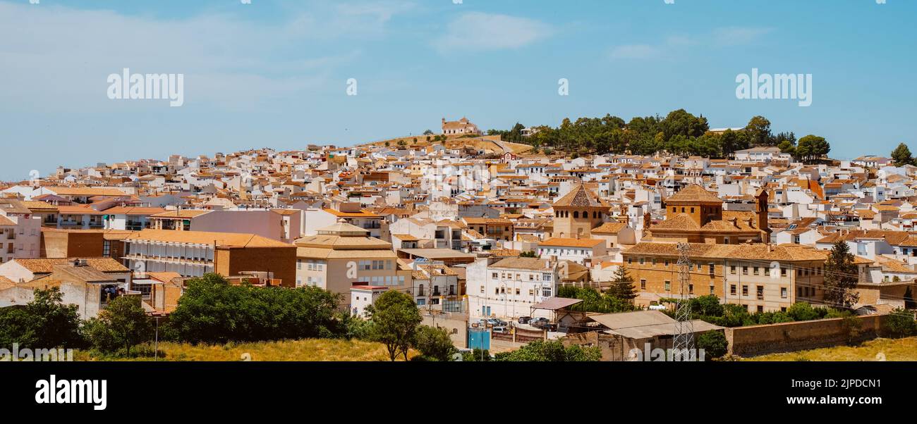 Una vista sobre los tejados de Antequera, en la provincia de Málaga, España, en un día de primavera, destacando el Santuario Vera Cruz en la cima de una montaña, en un pa Foto de stock