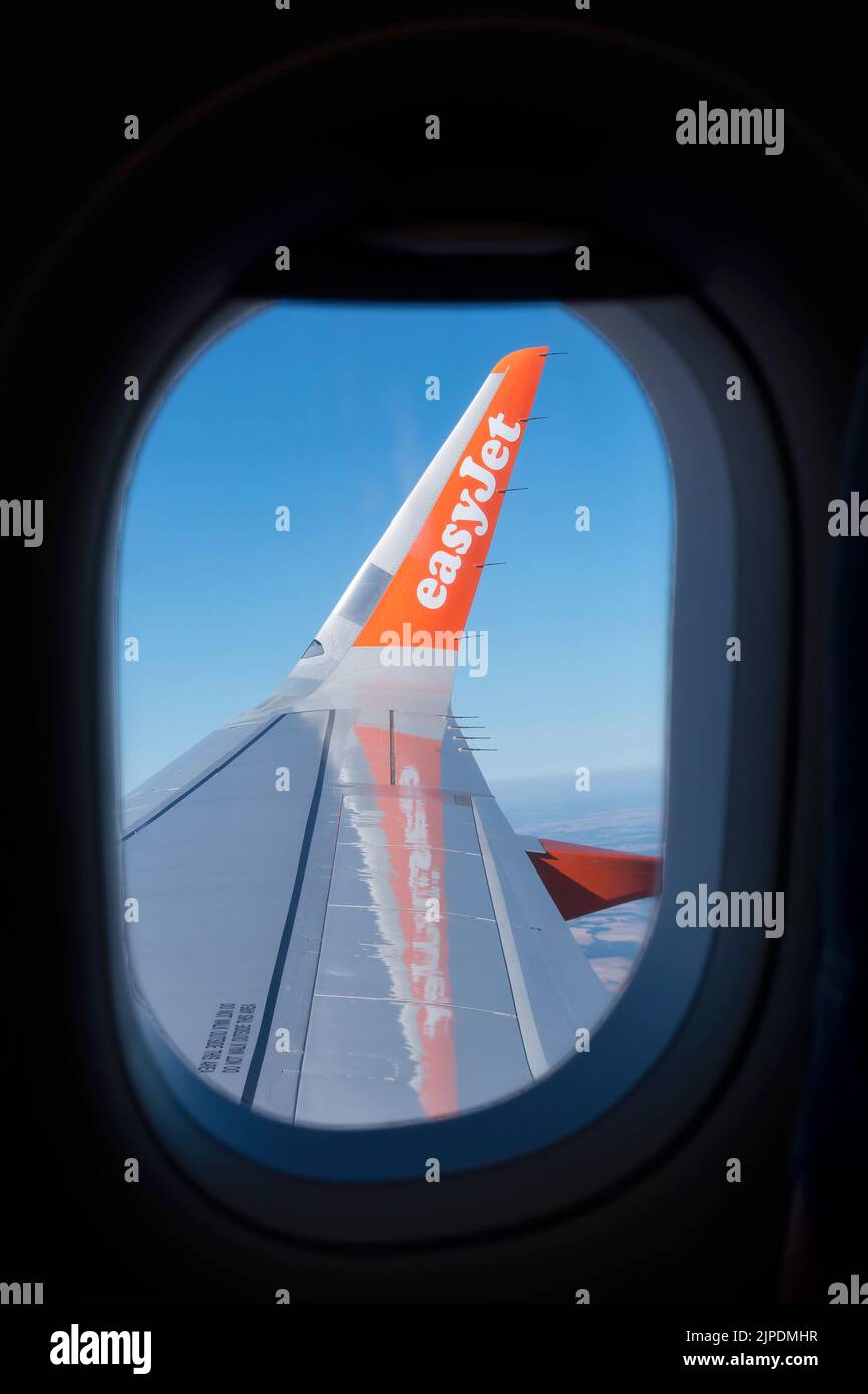 Un ala de avión EasyJet que se muestra en vuelo con una vista del pasajero desde la cabina del avión. El logotipo de la empresa se muestra claramente en el winglet de ala Foto de stock