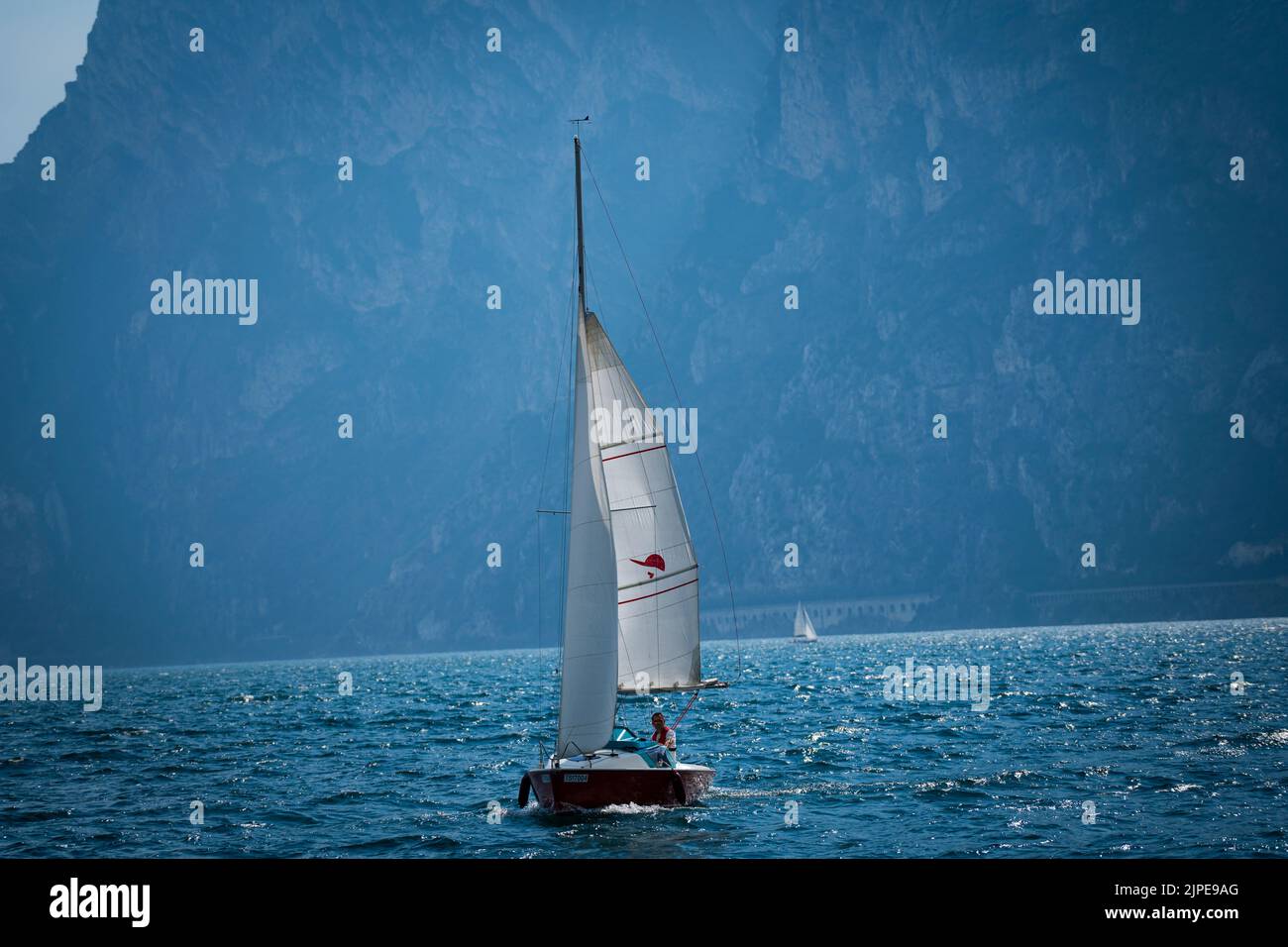 Torbole, Lago de Garda, Italia - 14 de mayo de 2022: Velero en el Lago de Garda en Italia con el telón de fondo de las montañas, velero en el Lago Foto de stock