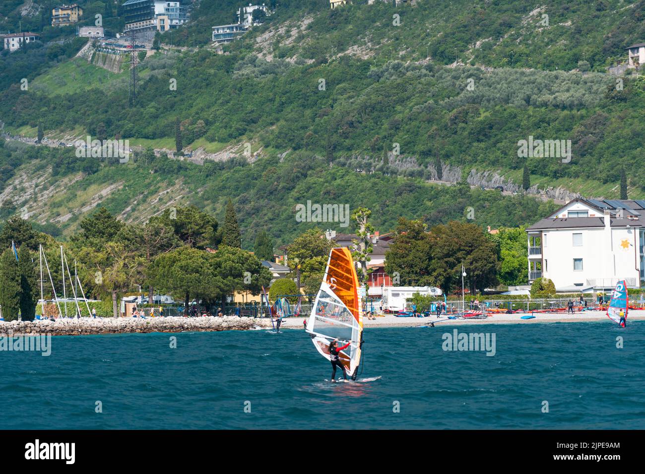 Nago-Torbole, Lago de Garda, Italia - 14 de mayo de 2022: Windsurf en una tabla de surf en la orilla norte del Lago de Garda en Italia, la ciudad de Torbole es popular Foto de stock