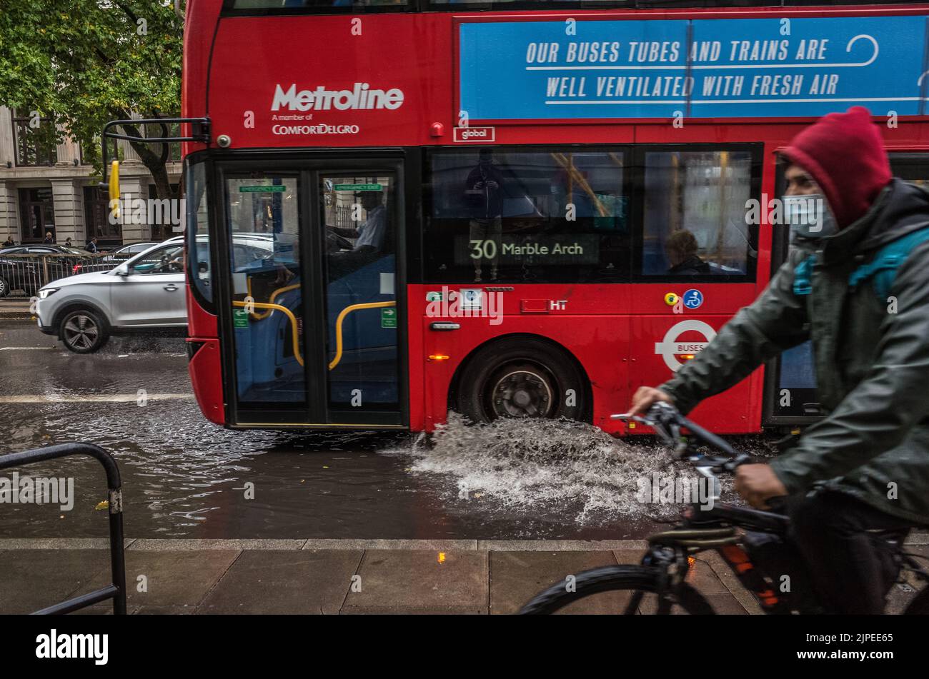 El autobús de Londres conduce a través de la carretera inundada Euston Road en Londres después de las inundaciones repentinas, Inglaterra, Reino Unido, Tiempo. Foto de stock