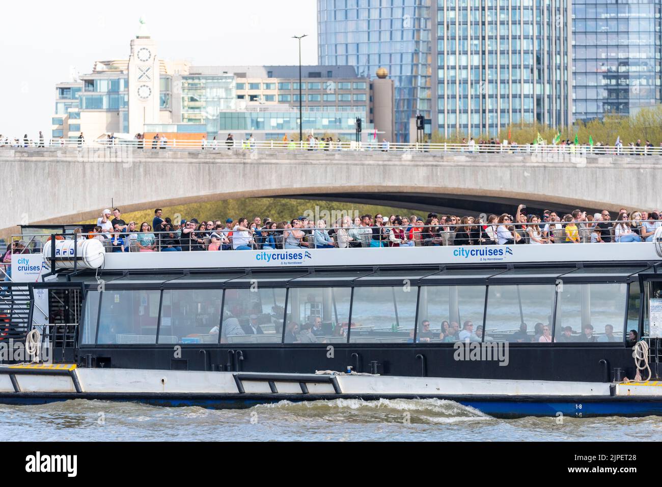 CityCruises, por Hornblower, barco turístico que pasa por debajo del puente Waterloo en Londres sobre el río Támesis. Paseo en barco Foto de stock