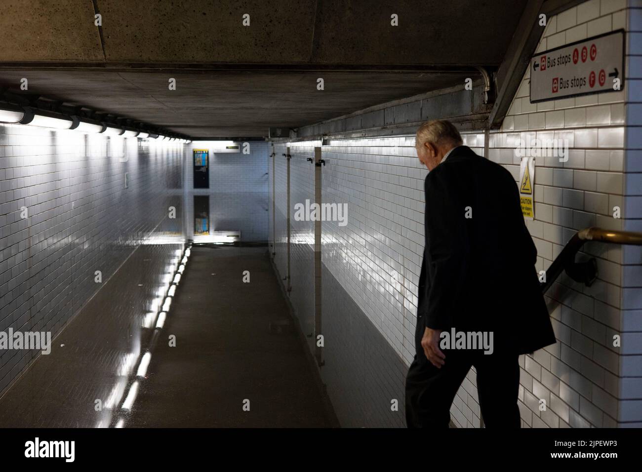 Un hombre visto tratando de caminar a través de un túnel inundado en la estación de metro de Westminster. Varias estaciones subterráneas se inundan esta tarde después de que las lluvias torrenciales azotaran Londres. El agua de lluvia lucha para penetrar el suelo seco a través de la superficie deshidratada y conducir a inundaciones repentinas después de lluvias torrenciales. Foto de stock