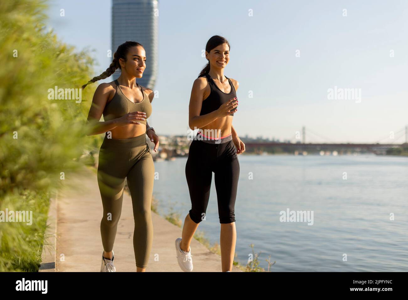 Una mujer bastante joven haciendo ejercicio junto al paseo del río Foto de stock