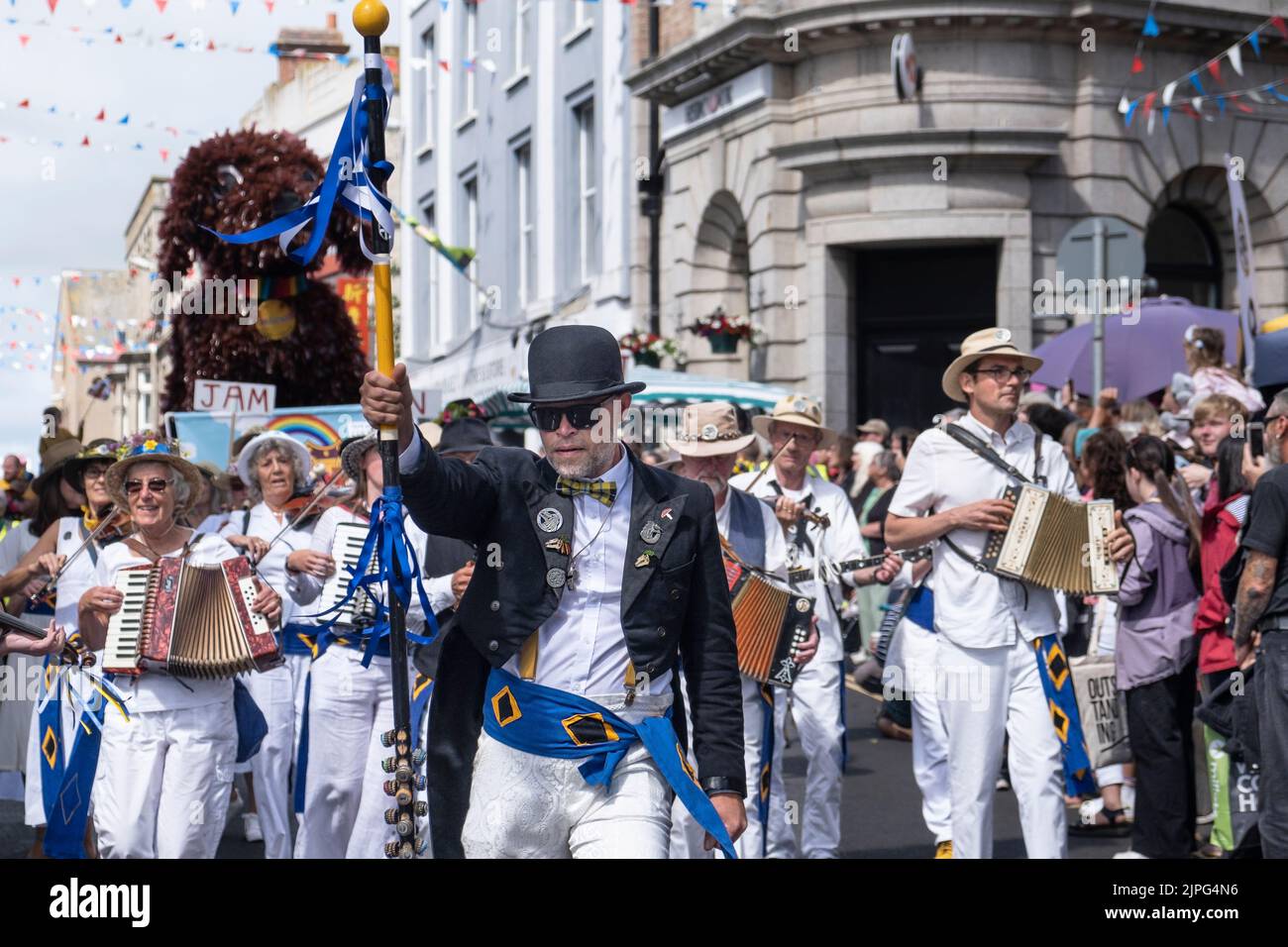 Tom White dirige la banda de Golowan actuando y desfilando por el centro de la ciudad de Penzance en la colorida procesión del día de Mazey en Cornwall en Inglaterra i Foto de stock