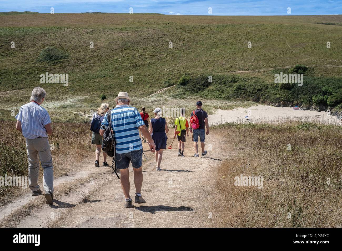 Turistas Visitantes Familia caminando a la solitaria broma Polly Porth en la costa de Newquay en Cornwall en el Reino Unido. Foto de stock