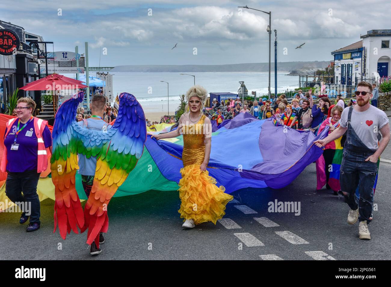 La enorme y vibrante pancarta de colores llevada por los participantes en el desfile Cornwall Pride Prides en el centro de Newquay Town en el Reino Unido. Foto de stock