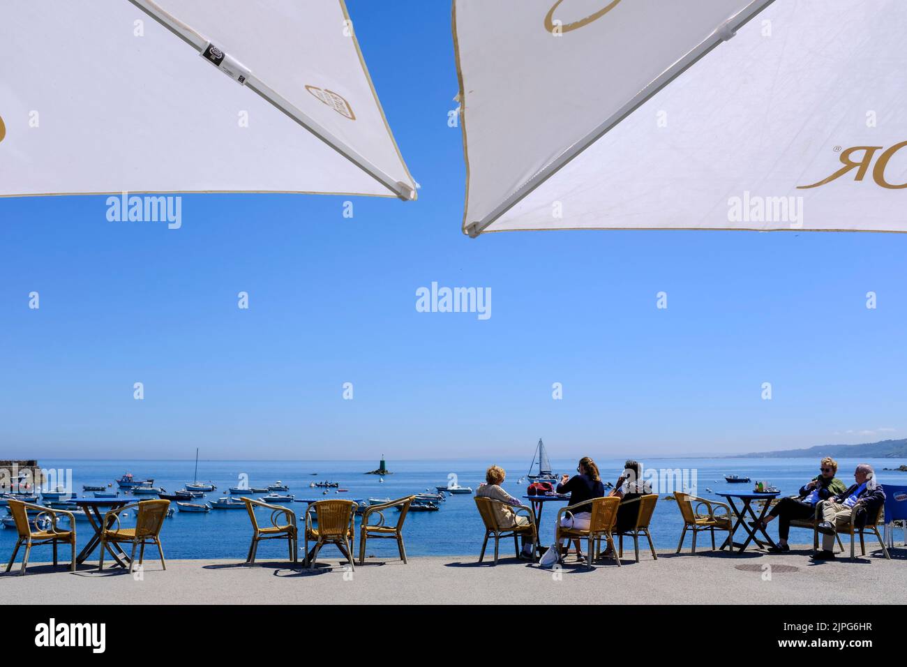 Frankreich, Omonville-la-Rogue, Le Hable, 08.07.2022: Menschen sitzen in der Sonne direkt am Hafen Le Hable vor einem Restaurante en Omonville-la-Rogue Foto de stock