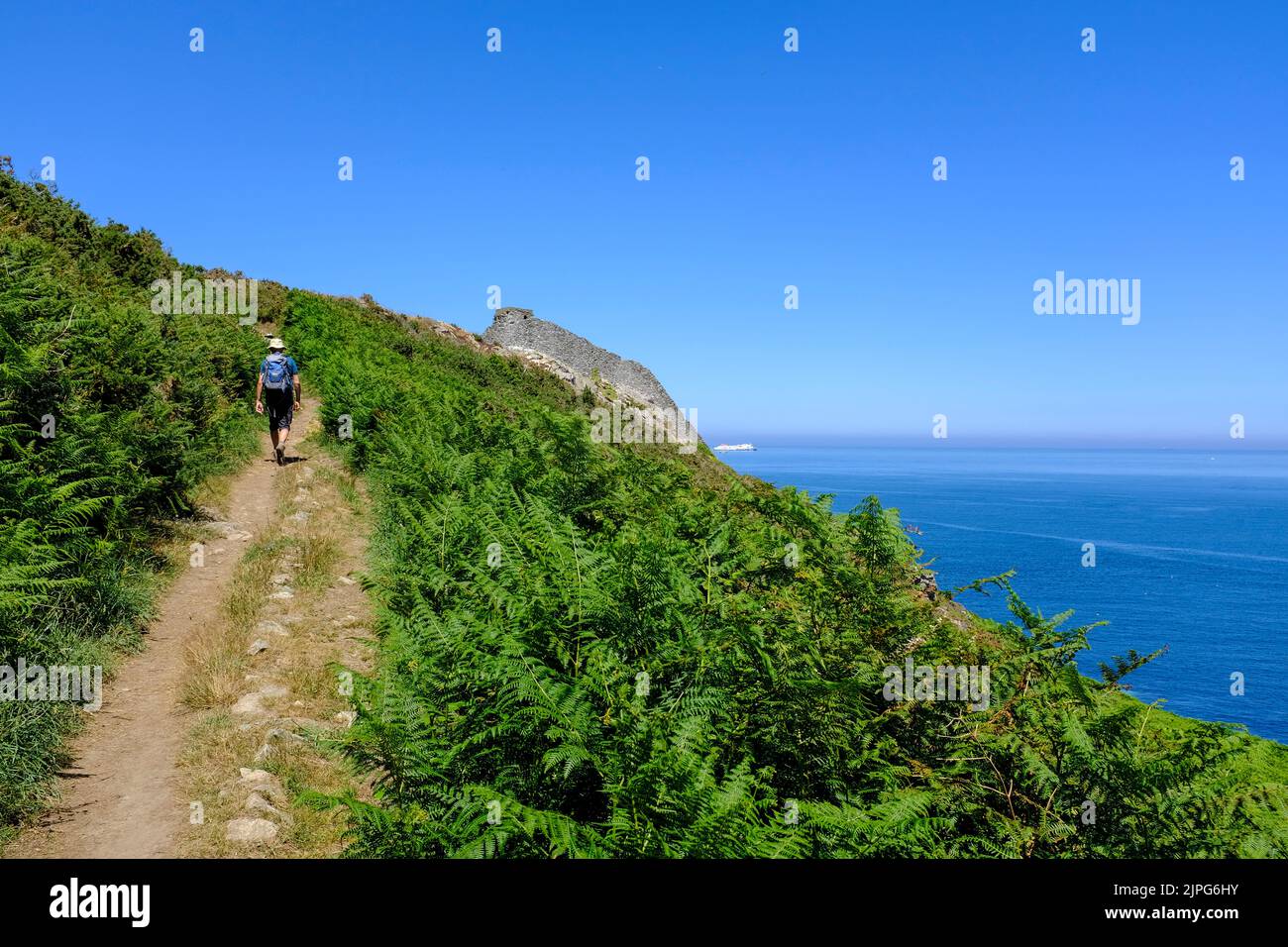Frankreich, La Hague, Omonville-la-Rogue, 08.07.2022: ein einzelner Wanderer auf dem Kuestenwanderweg in der Naehe des Cap de la Hague bei Omonville-l. Foto de stock