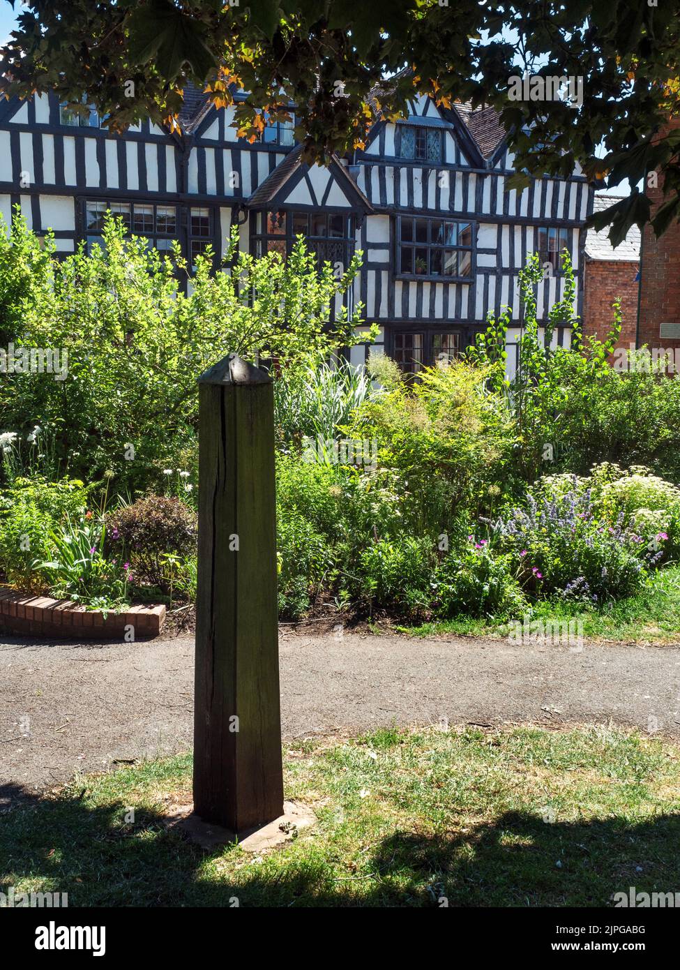 Monumento de madera en el jardín amurallado con la Casa de la Iglesia detrás de Ledbury Herefordshire Inglaterra Foto de stock