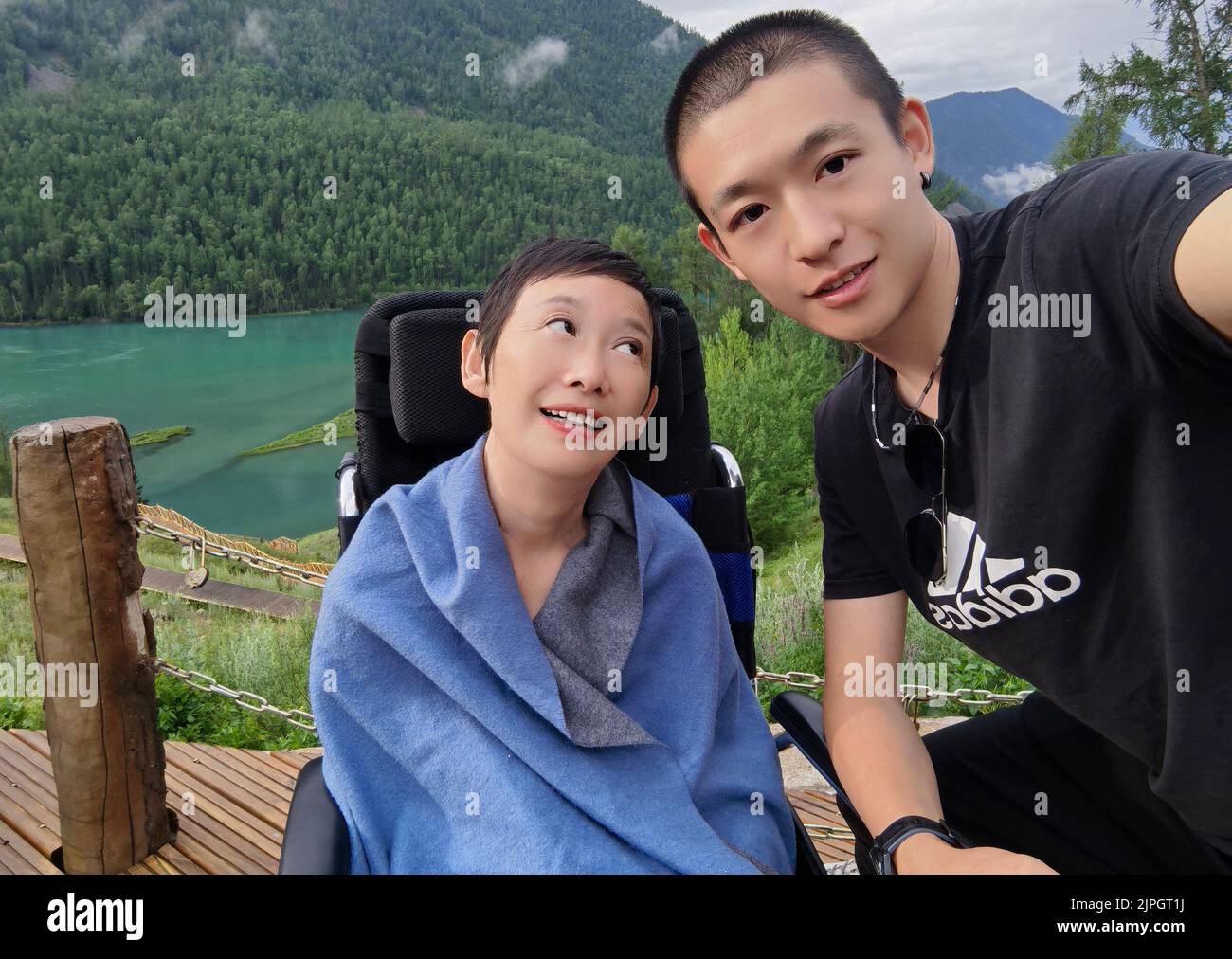 (220818) -- ZHENGZHOU, 18 de agosto de 2022 (Xinhua) -- Zhao Tianci (R) posó para una foto con su madre Liu Wenian durante su viaje a la región autónoma de Xinjiang Uygur, en el noroeste de China, el 30 de junio de 2022. Liu Wenyan se considera afortunada. A pesar de estar confinada a una silla de ruedas la mayor parte del tiempo, ha terminado recientemente un viaje por carretera que abarca más de 15.000 km. El viaje de ida y vuelta desde su ciudad natal de Shangqiu, en la provincia de Henan, en el centro de China, a la región autónoma de Xinjiang Uygur, en el noroeste de China, y de nuevo tomó 31 días. Liu, de 52 años, padece una enfermedad neurodegenerativa llamada amiotrófica LA Foto de stock