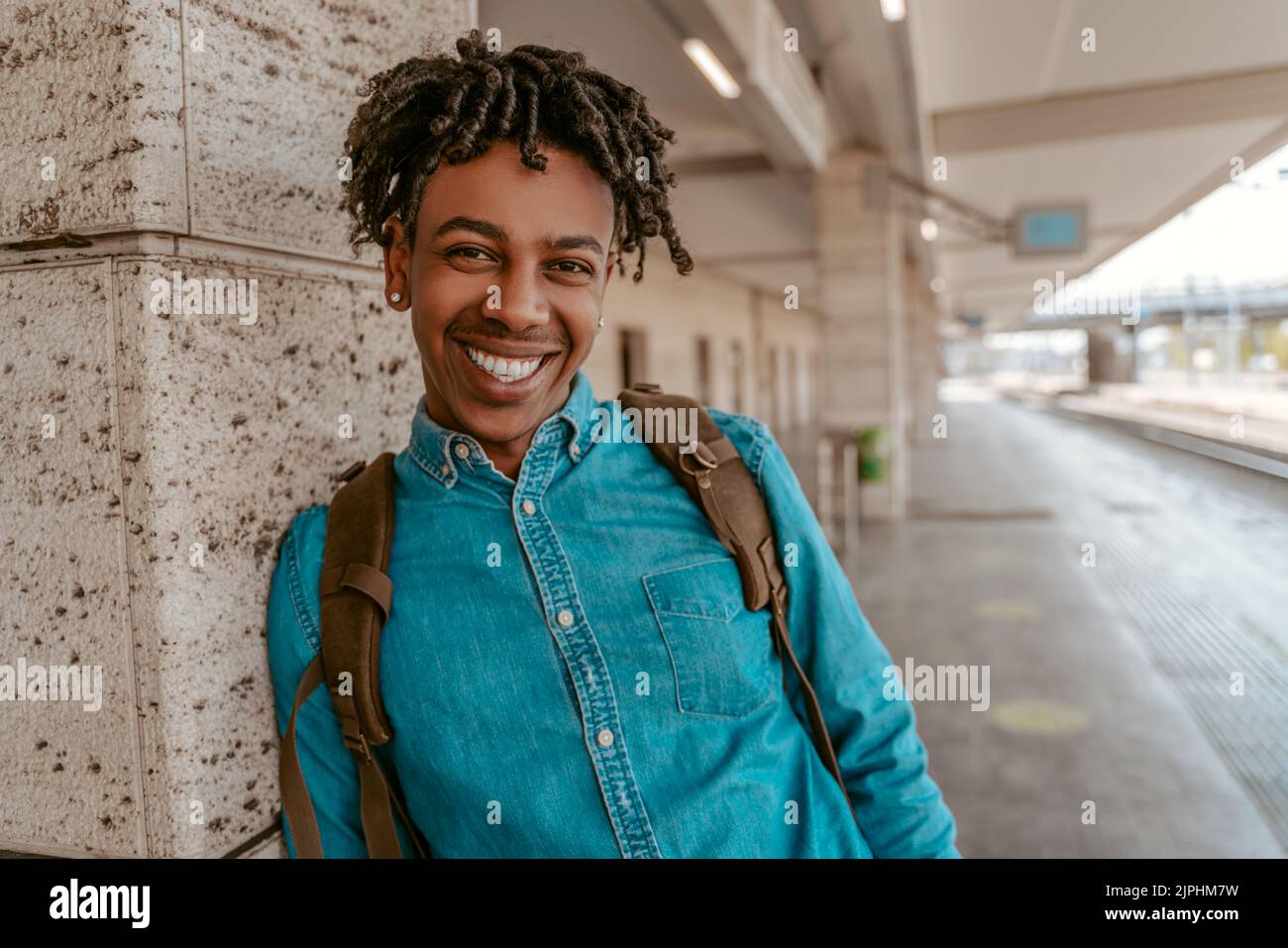 Un hombre africano sonriendo a la cámara en la estación de tren Foto de stock