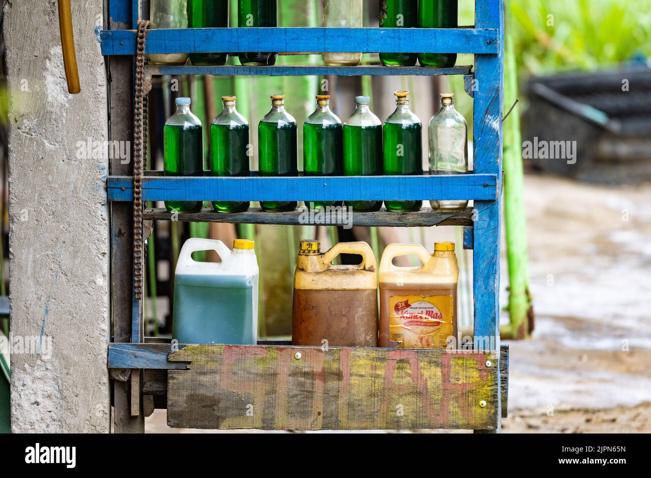 Gasolina vendida en botellas en el mercado negro. Sulawesi, Indonesia. Foto de stock