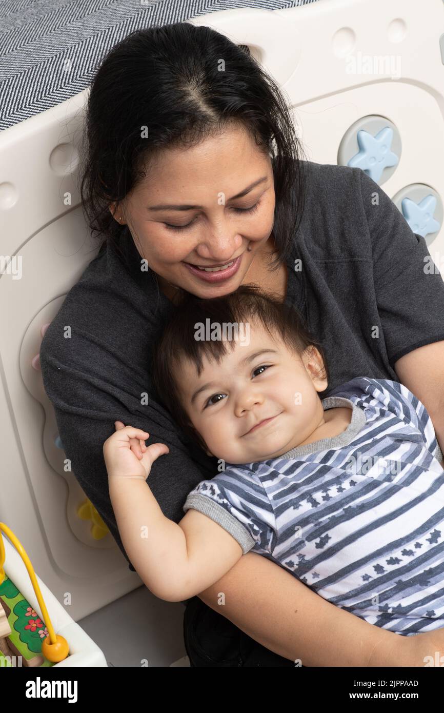 retrato de niño de 11 meses en casa con madre cariñosa Foto de stock