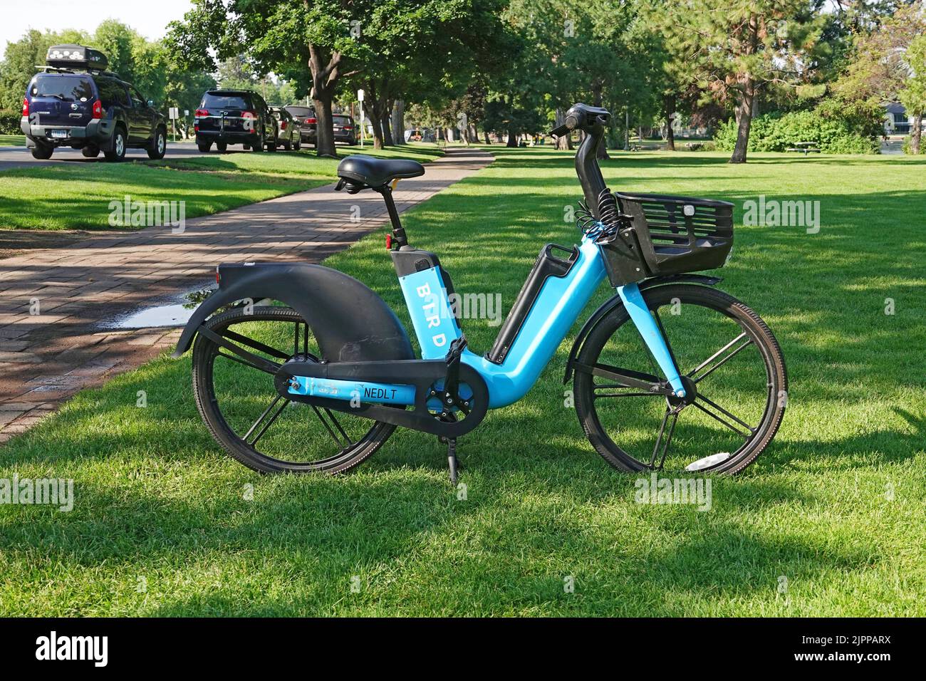 Una bicicleta eléctrica de alquiler con un neumático desinflado estacionada en un parque de la ciudad en Bend, Oregón. Foto de stock