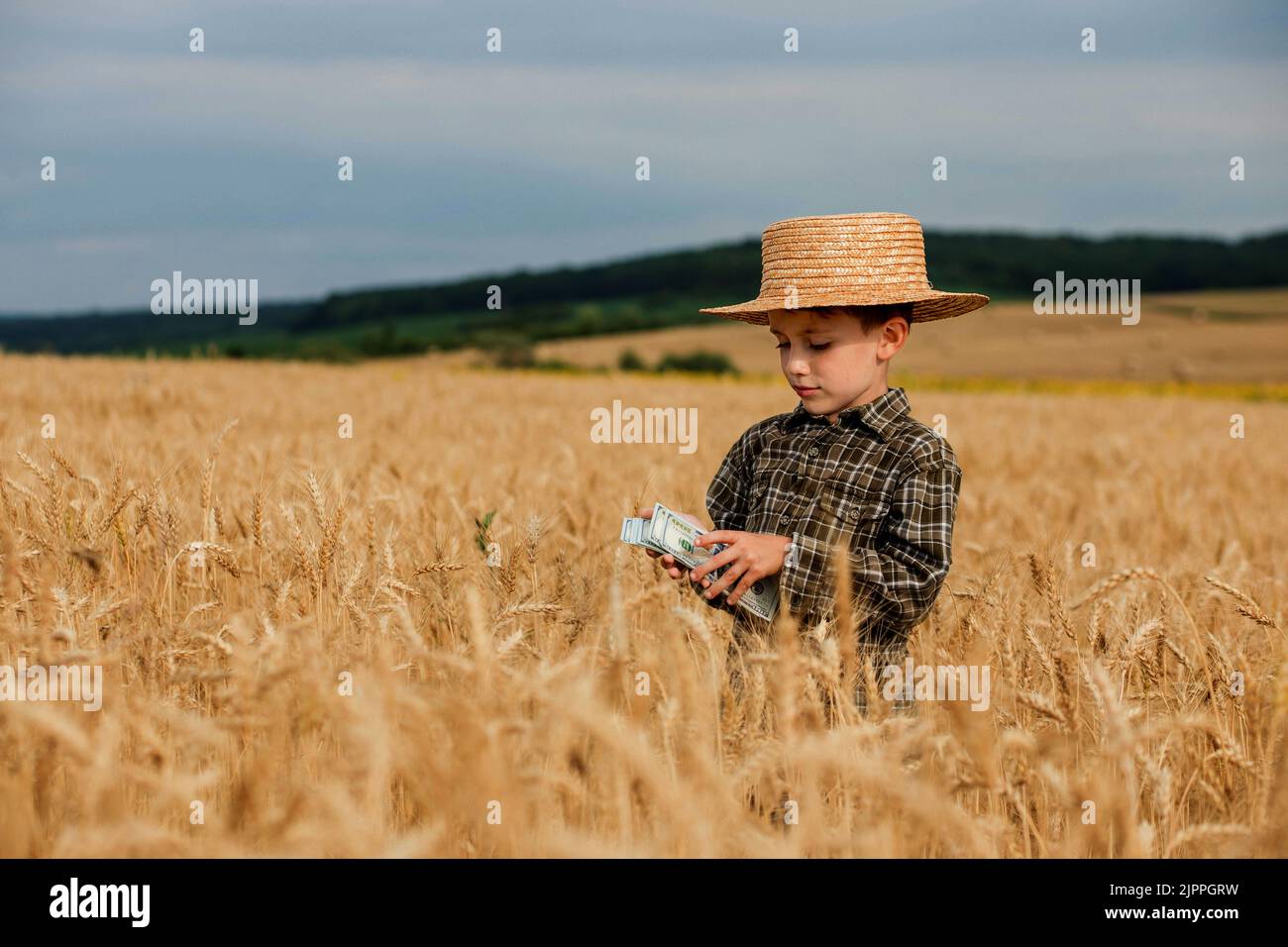 Niña niño con sombrero de paja en ropa amarilla come maíz