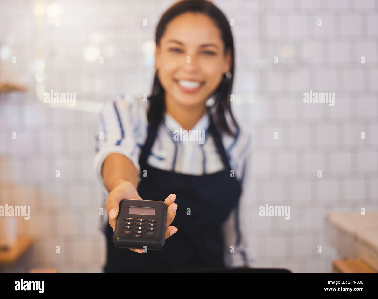 Pago, lector de tarjetas y dinero con un empleado de cafetería amigable o trabajador de cafetería sosteniendo un escáner para dar servicio a un pedido. Toca para pagar, nfc y sencillo Foto de stock