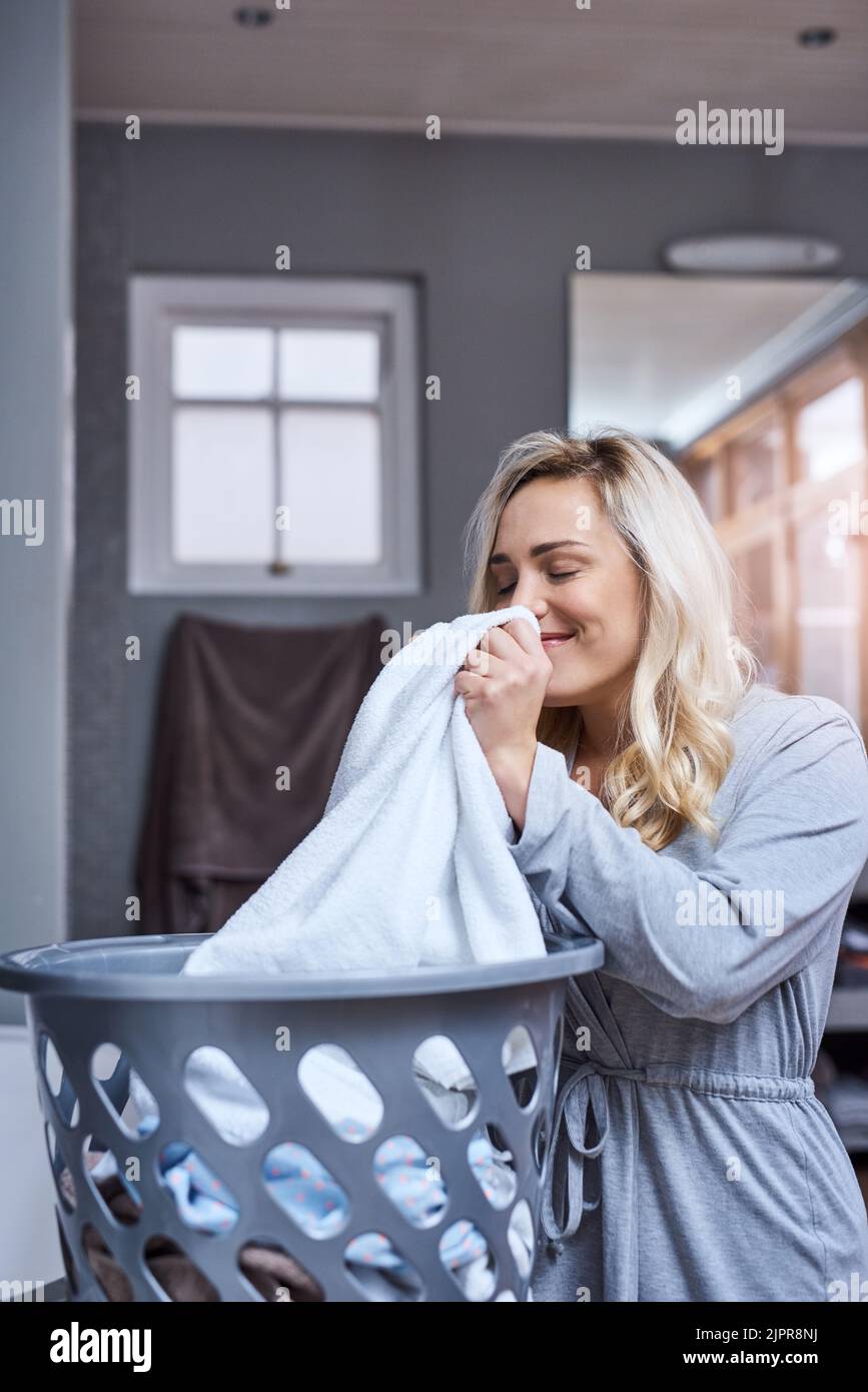 Me encanta el olor fresco de la ropa limpia. Una mujer joven oliendo la ropa  fresca y limpia en casa Fotografía de stock - Alamy