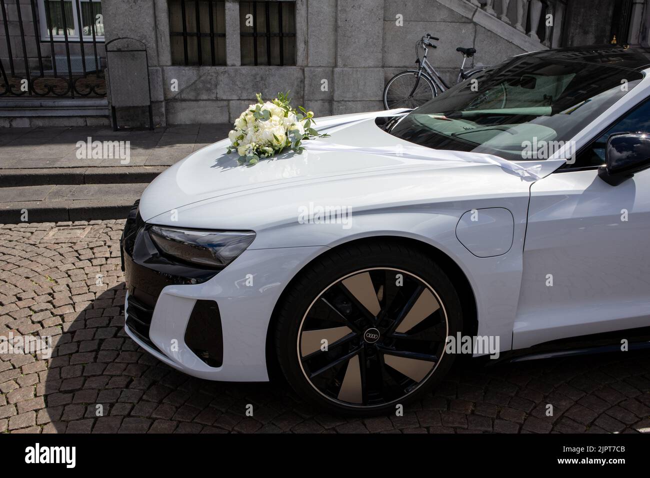 Un coche blanco de la boda con un ramo de flores en la capucha Foto de stock