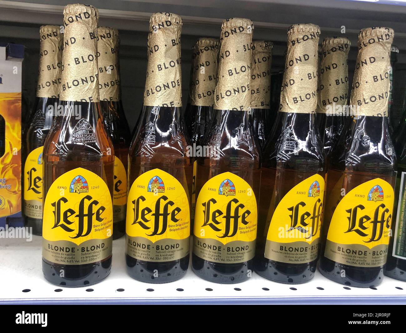 18.08.2022 Ucrania, Kharkiv, estante con cerveza en botellas de vidrio en un supermercado. Cerveza belga de alta calidad Foto de stock