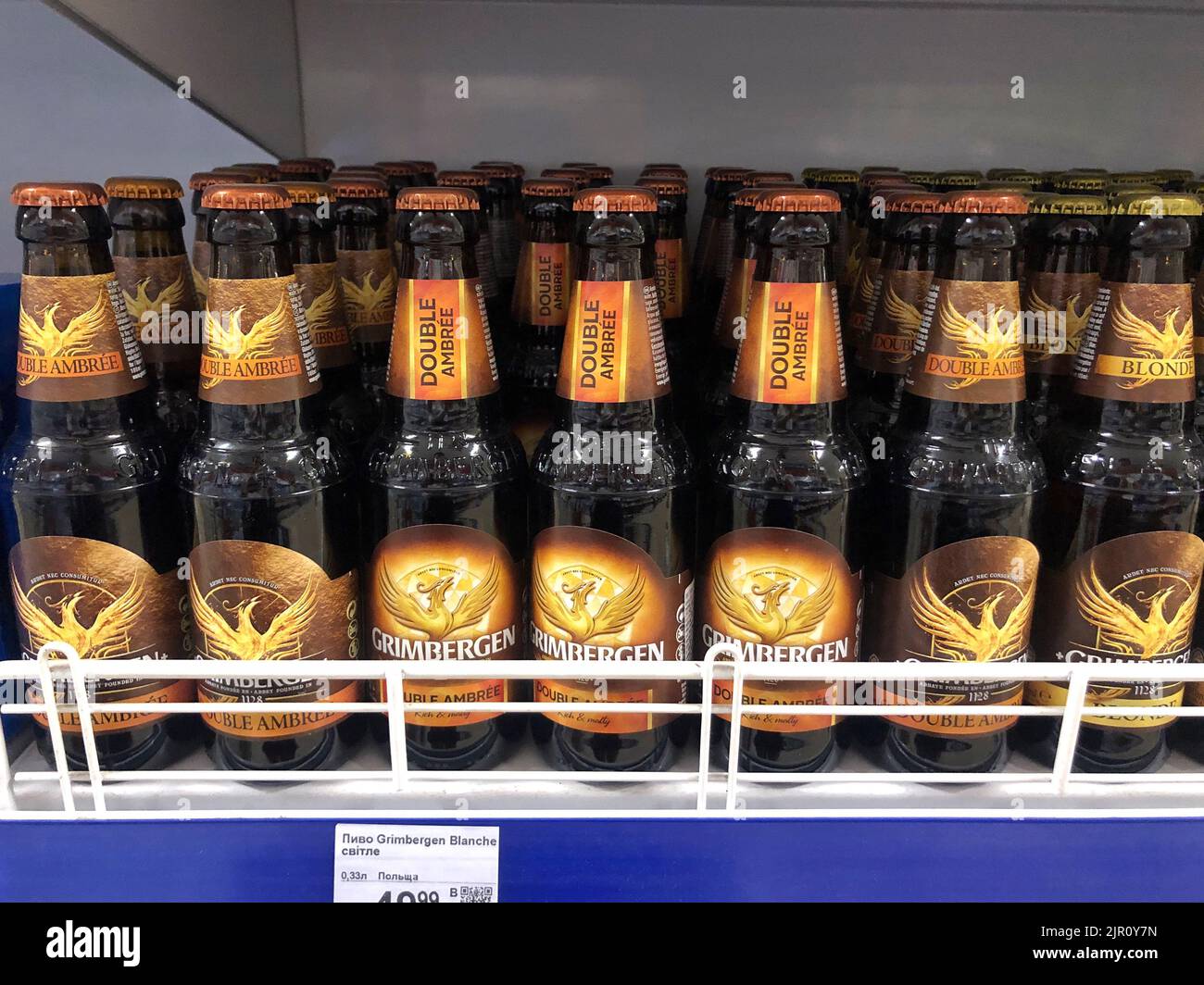 14.08.2022 Ucrania, Kharkiv, estante en un supermercado con cerveza en botellas de vidrio. Cerveza belga de trigo de alta calidad Foto de stock