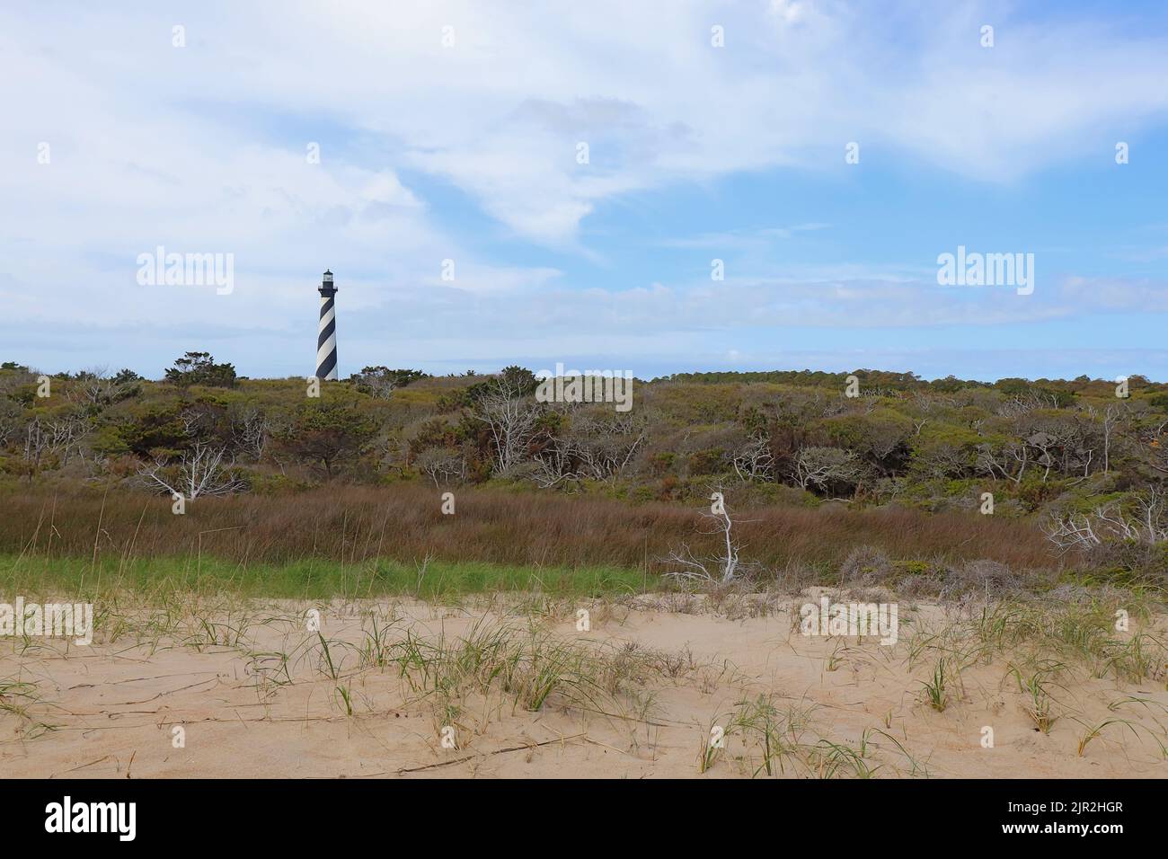 La torre del faro de Cabo Hatteras cerca de la ciudad de Buxton en las orillas exteriores de Carolina del Norte desde la playa Foto de stock