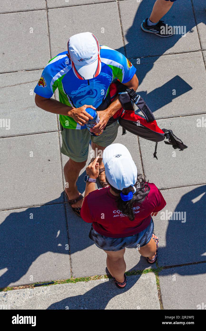 Los miembros del equipo del barco dragón comentan su carrera en el Festival Steveston 2022 en British Columbia, Canadá Foto de stock