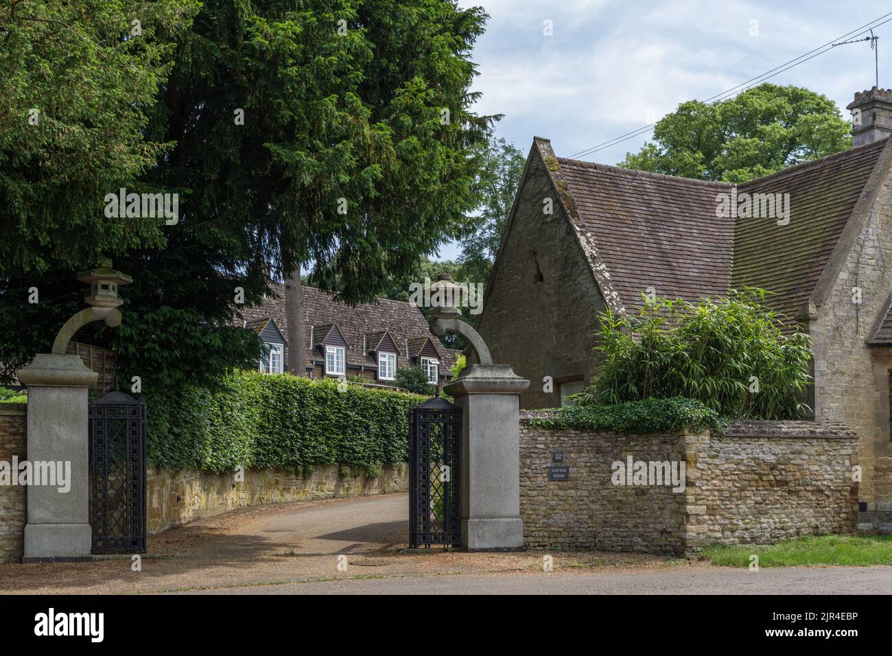 Gayton House, una propiedad de época en el pueblo de Gayton, Northamptonshire, Reino Unido; puertas y postes de Sir Clough Williams-Ellis Foto de stock