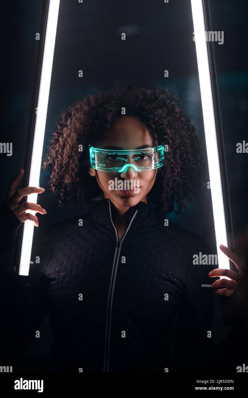 Tecnología digital metaverse del cibermundo, mujer joven con gafas inteligentes, estilo de vida futurista Foto de stock