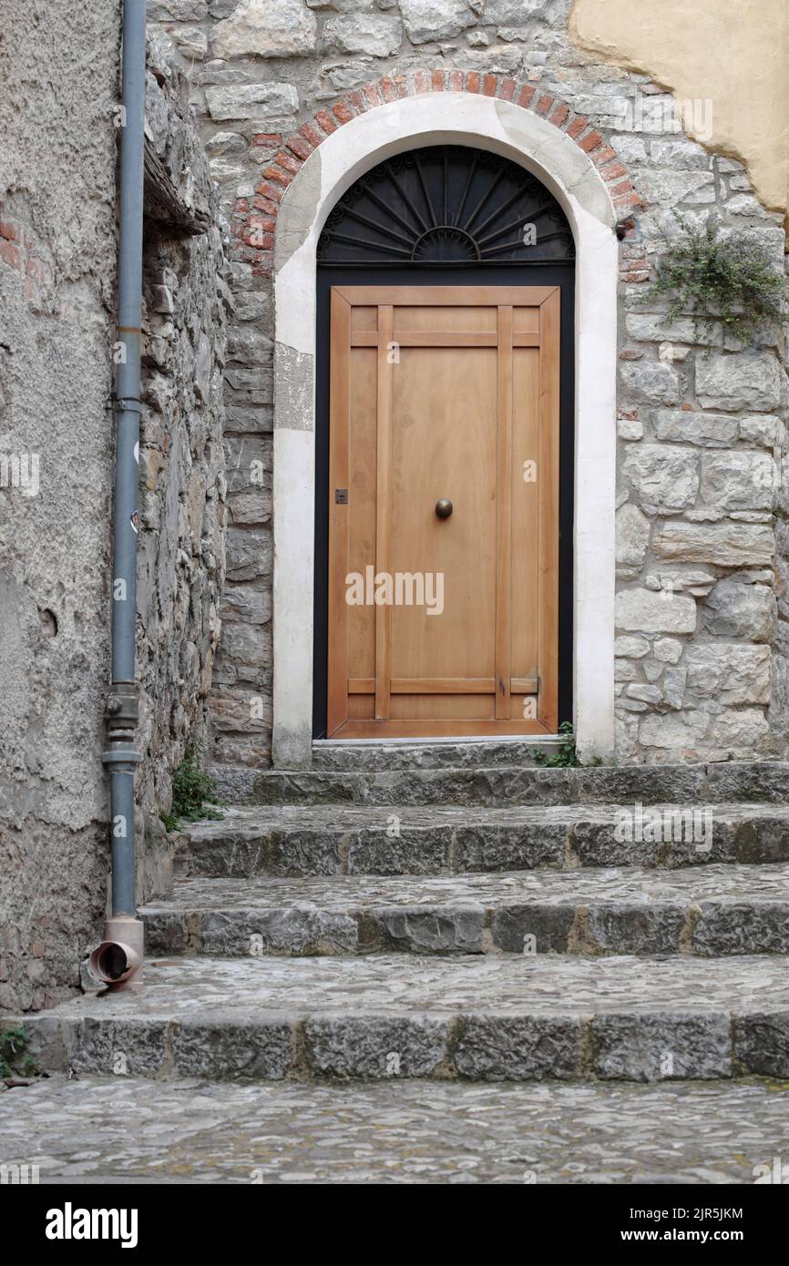 A pasos de la puerta de madera en una antigua calle de Caccamo en Sicilia, Italia Foto de stock