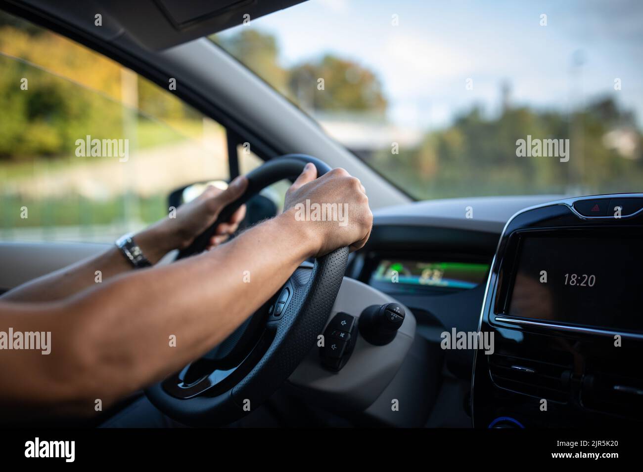 Joven conduciendo un vehículo eléctrico en un contexto de la ciudad. Compartir coche concepto. eCar concepto. Foto de stock