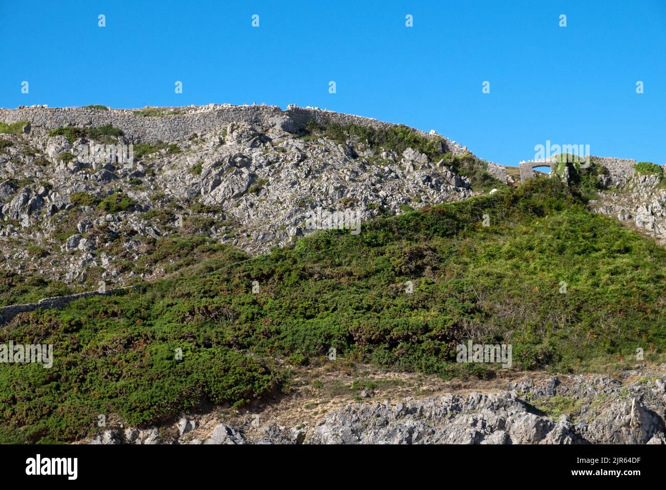 Pared de piedra seca sobre un precipicio de roca en la bahía de Barafundle y cielo azul con espacio de copia en Pembrokeshire Wales UK 2022 Gran Bretaña KATHY DEWITT Foto de stock
