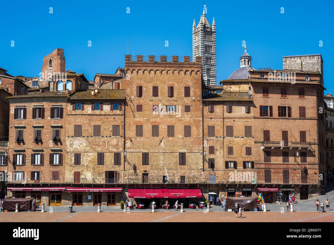 Edificios medievales que rodean la Piazza del Campo con el campanario Campanile en el horizonte de Siena, Toscana, Italia Foto de stock