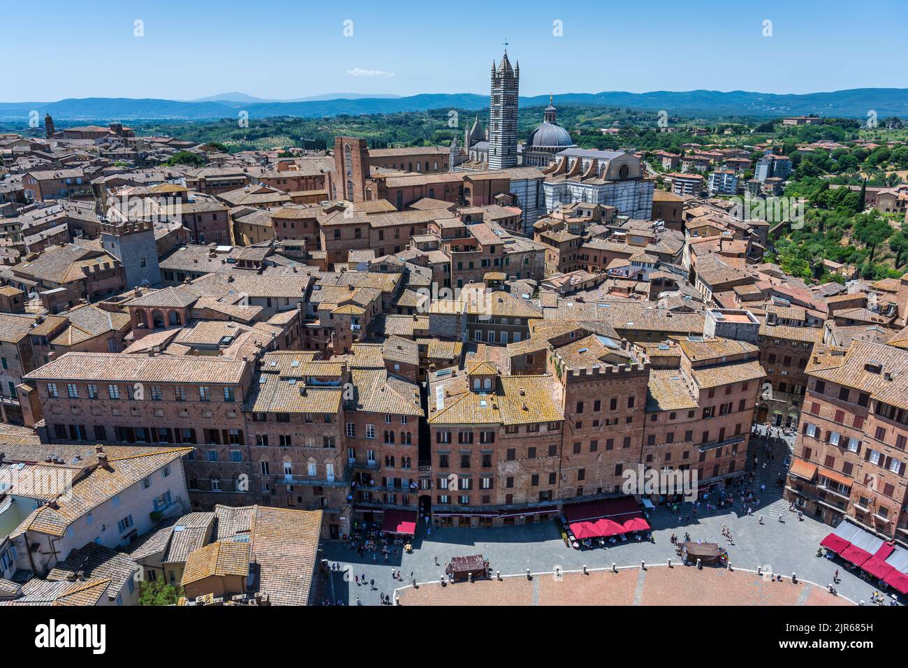 Vista desde la parte superior del campanario de Torr del Mangia mirando hacia abajo en la Piazza del Campo y los tejados rojos más allá del Duomo en Siena, Toscana, Italia Foto de stock