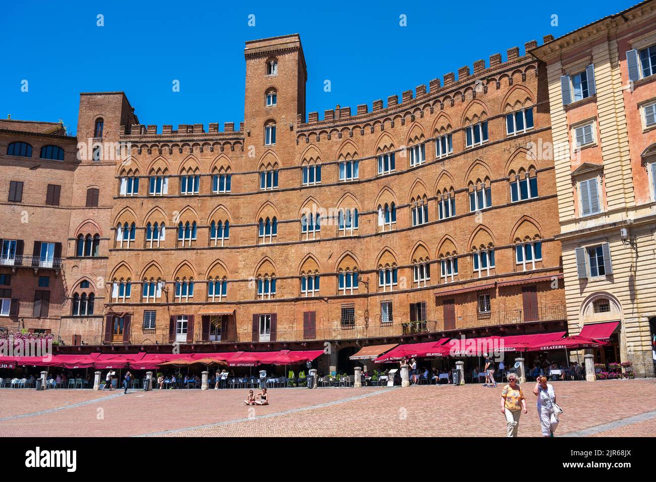 Cafés al aire libre y edificios medievales que rodean la Piazza del Campo en Siena, Toscana, Italia Foto de stock